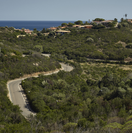 View of the hills overlooking the sea of Costa Rei in the south of Sardinia, with above them the villas used as summer residences for tourists who visit this place.の写真素材