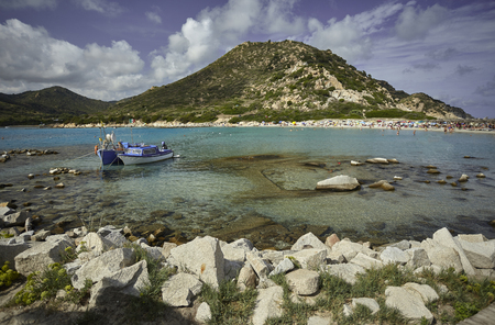 Beautiful view of Punta Molentis, a natural beach on the southern coast of Sardinia with a couple of small fishing boats moored on the shore.の写真素材