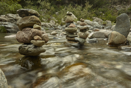 Piles of zen rocks in the middle of the mountain stream with the movement of the water.の写真素材