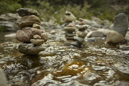 Stack of round rocks in the middle of the mountain stream water.の写真素材