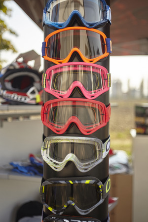 Display of colored motocross spectacles and different models at a fair stand.の写真素材