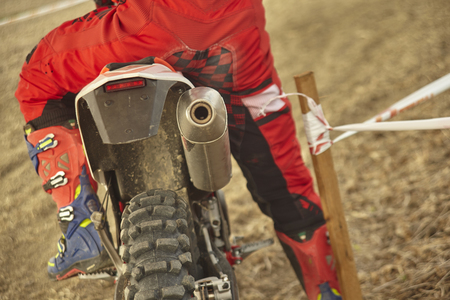 Detail of the back of a cross bike with the rider in the saddle ready to go for the raceの写真素材
