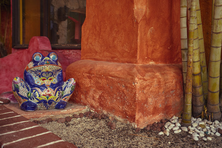Decoration in the shape of a frog statue inside a flowerbed in Playa del Cramen: Symbol of an ancient culture that used the extracts of certain frogs from which they derived hallucinogenic substances.の写真素材
