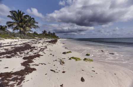 Wide angle view of Xpu-Ha beach in Mexico during a sunny day with scattered clouds that sometimes cover the light.の写真素材