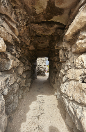 Small tunnel with stone brick walls create passages between the walls of the ruins of Tulum in Mexicoの写真素材