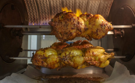 Spit-roasted chickens are cooked in a roasting oven inside a rotisserie