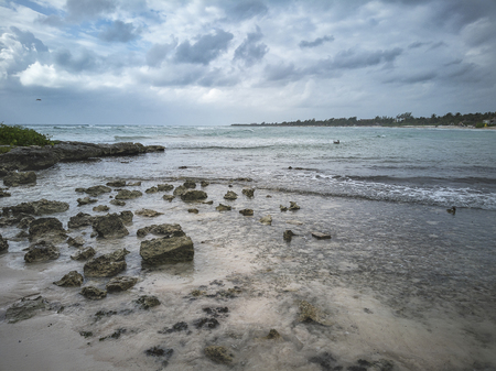 View of the natural beach of Xpu-Ha in the Mayan Riviera in Mexico under a cloudy winter sky.の写真素材