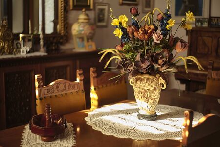 Still life of a living room interior containing a wooden table resting on a vase of dried flowersのeditorial素材