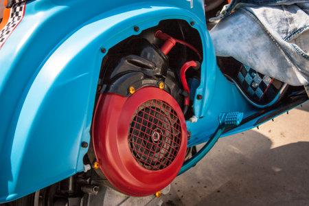 Detail of the uncovered customized engine of a vintage means of transport: Piaggio's Vespa.