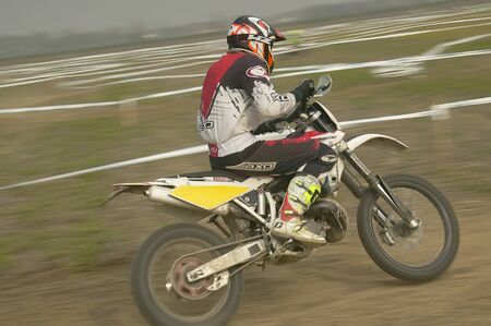 Motocross rider intent on driving his motorbike to the finish line in a motocross race on a trackのeditorial素材