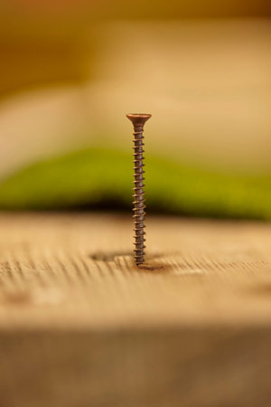 Self-tapping metal screw partially screwed into a wooden artifact inside a joinery