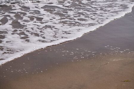 Sea waves on shoreline on orange sandのeditorial素材