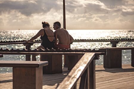DOMINICUS, DOMINICAN REPUBLIC 6 FEBRAURY 2020: People sitting on the bench by the seaのeditorial素材