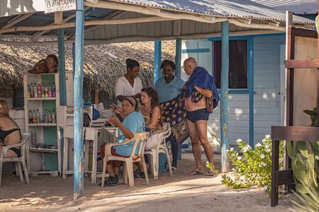 DOMINICUS, DOMINICAN REPUBLIC 6 FEBRAURY 2020: Dominican people socialize under a gazebo on the beachのeditorial素材
