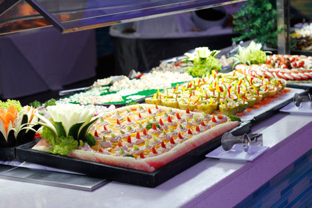 Tray full of cupcakes and slices of cake inside a buffet
