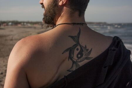 Boy shows the tattoo on his backの写真素材