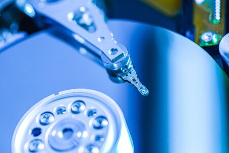 Detail of the inside of a hard disk with the reading head in operation, blue light imageの写真素材