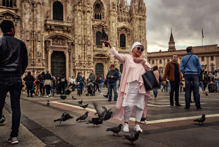 MILAN, ITALY 10 MARCH 2020: Tourist posing for a photo in front of the Milan cathedralのeditorial素材