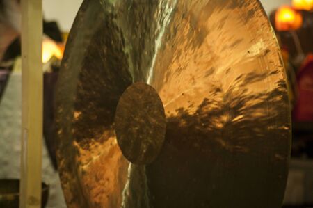 Golden oriental gong with reflection on metal materialの写真素材