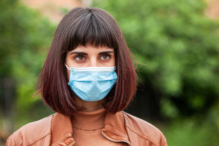 Close up Portrait of a Girl with medical mask outdoor during covid quarantine in Italy
