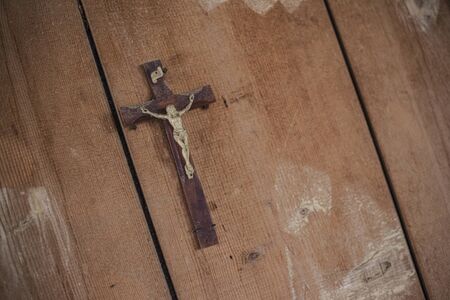 Detail of a Crucifix in an abandoned building on a wooden wallの写真素材