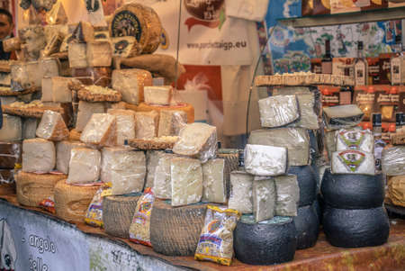 ROVIGO, ITALY 26 OCTOBER 2021: Stall full of cheeses for sale. A pile of cheese with selective focus, Cheese from farm in the market stall.のeditorial素材