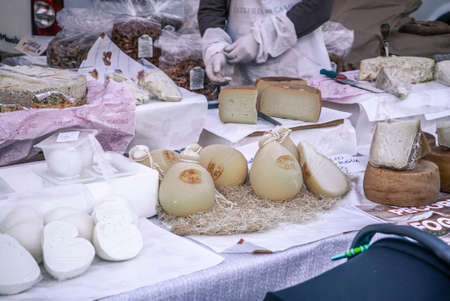 ROVIGO, ITALY 26 OCTOBER 2021: Stall full of cheeses for sale. A pile of cheese with selective focus, Cheese from farm in the market stall.のeditorial素材