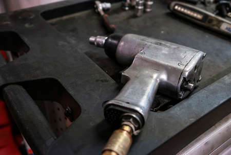 Pneumatic screwdriver detail or impact wrench posed in a workshop benchの写真素材