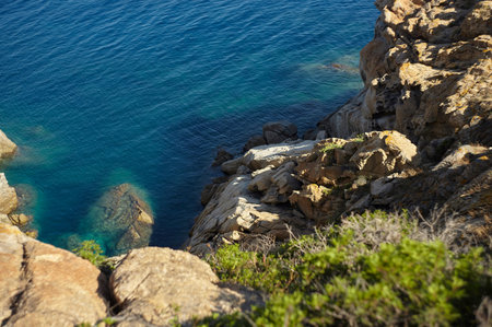 Cliff on the southern coast of Sardinia with granite rocks that rise from the sea below.
