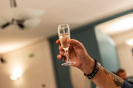 Glass raised in hand for the toast detailの写真素材