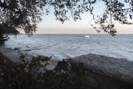 A breathtaking view of the picturesque shoreline of Lake Garda, surrounded by the majestic mountains...