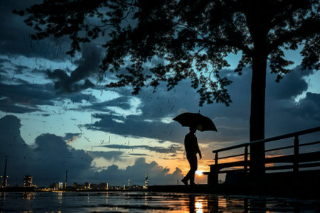 Intriguing photo capturing the silhouette of a man with an umbrella, shrouded in mystery and allureの素材