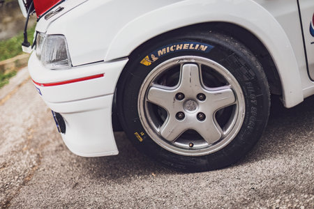 Gavello, Italy 23 June 2024: Close-up of a Peugeot 106 rally car with extra headlights and sponsor stickers parked on a streetのeditorial素材