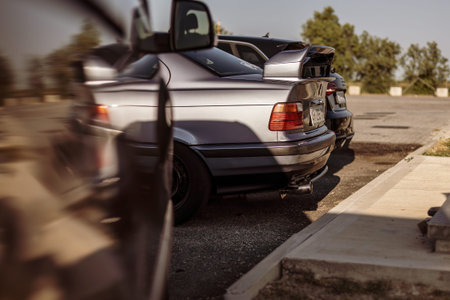 Adria, Italy 30 July 2024: Rear view of a retro BMW sports car with a spoiler parked at a gas...