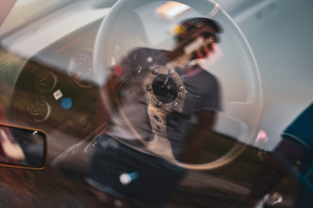 A blurred reflection of a man through a car's steering wheel with vintage details.の写真素材