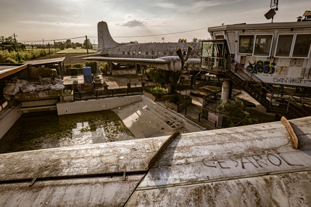 Rusty airplane and empty swimming pool in decaying amusement park showing urban exploration conceptの写真素材