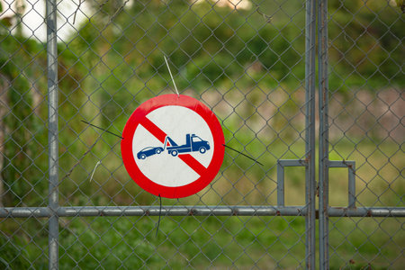 Bayahibe, Dominican Republic 1 January 2025: Round no parking sign hanging on a metal fence in dominicus, prohibiting parking and warning of towingの写真素材