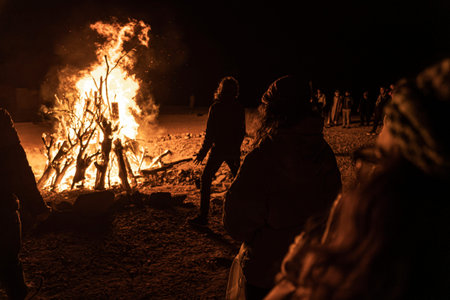 Tourists gathered around a warm bonfire in the Marsa Alam desert, enjoying the night under a sky...