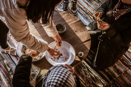 Group enjoying a traditional meal on a rustic table, surrounded by colorful textiles in the Marsa...