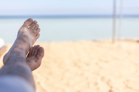 Sandy feet enjoying the relaxing atmosphere of a beach in Marsa Alam, Egypt, with the clear blue sea...
