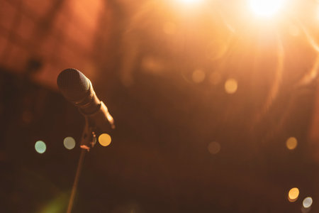 Professional microphone on stage under warm lights, ready for a singer to start performingの写真素材