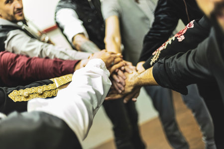 Musicians joining hands in a circle, demonstrating teamwork and unity before a performanceの写真素材