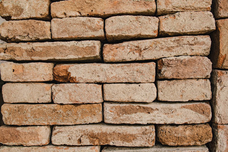 Close up of an old brick wall, highlighting the texture and deterioration of the bricks, creating a rustic and weathered appearanceの写真素材