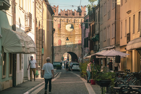 Rovigo, Italy 21 June 2025, tourists and citizens walking in the city center of Rovigo under the Porta Arqua gate on a sunny day, Veneto, Italyの写真素材