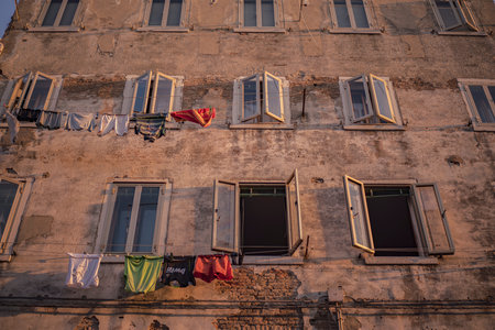 Chioggia, Italy 21 June 2025, laundry hanging on clotheslines outside windows of old building in Chioggia, Italy, creating a picturesque scene of everyday lifeの写真素材