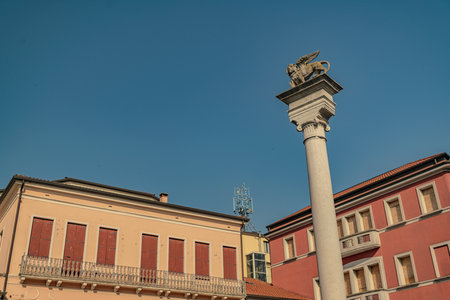 Rovigo, Italy 21 June 2025, white marble column topped with the winged lion of saint mark statue, symbol of the most serene republic of venice, in rovigo, italyの写真素材