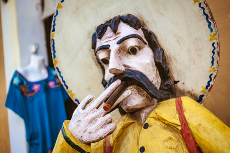 Traditional wooden statue of a mexican man wearing sombrero and smoking cigar, representing local culture in valladolid, yucatan, mexicoの写真素材
