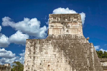 Impressive stone walls of the Mayan temple of the great ball court rising towards a vibrant blue sky...