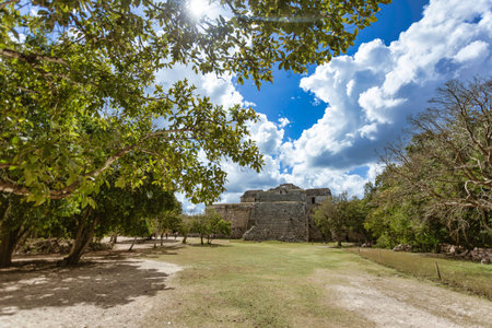 Sunlight illuminates the observatory at Chichen Itza, showcasing Mayan architecture against a...