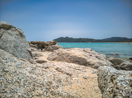Breathtaking view of the turquoise waters and granite rocks on the beach of cala sinzias, a stunning...